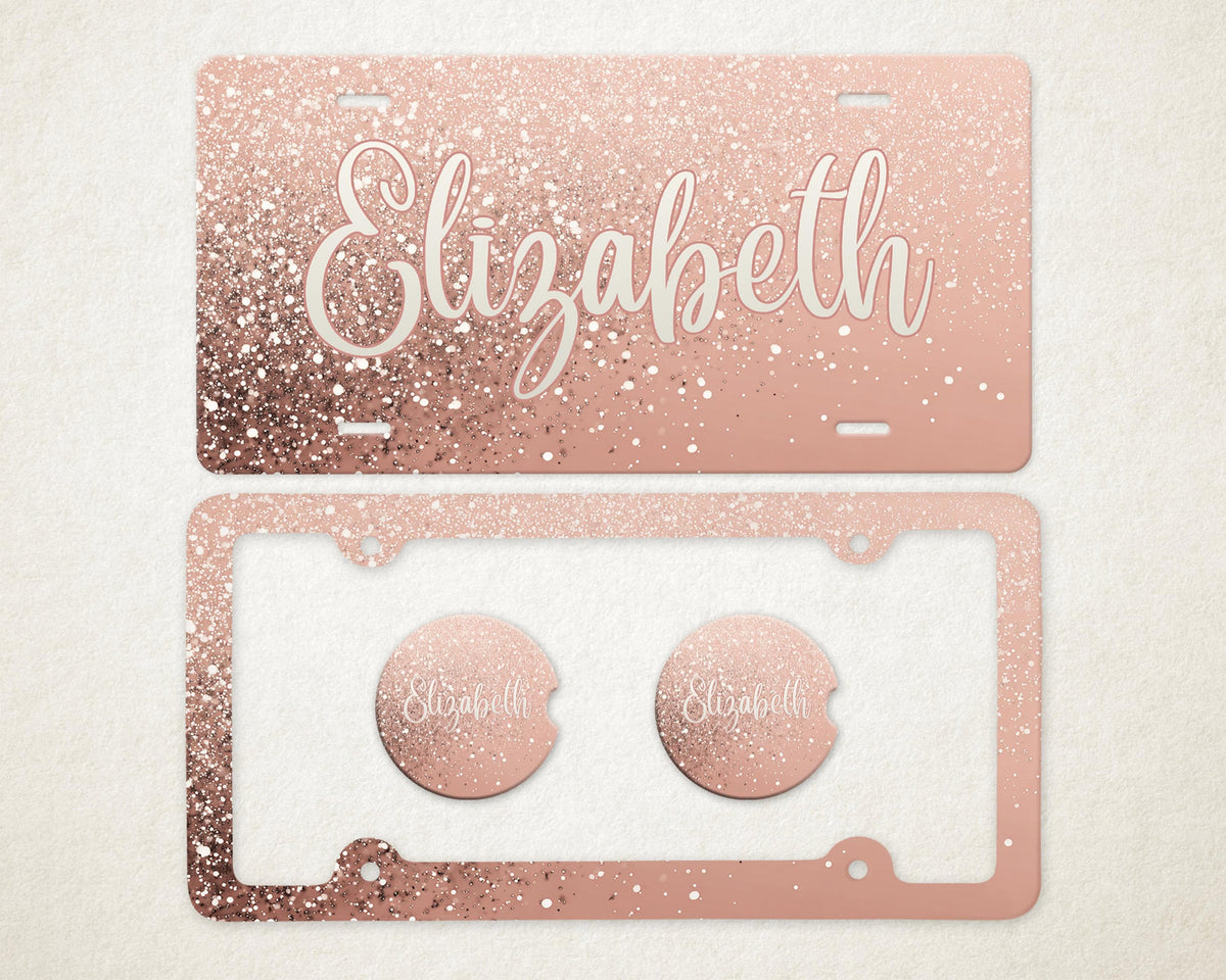 May include: Rose gold glitter license plate and frame set with the name "Elizabeth" in a white script font. The set includes two matching car coasters. The license plate and frame have a sparkly, glittery appearance.