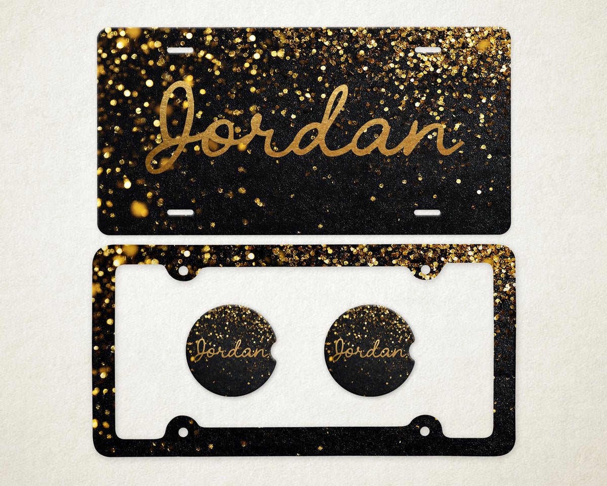 May include: A black license plate and car coaster set with gold glitter and the name "Jordan" in gold script. The license plate has a black background with gold glitter. The car coasters have the name "Jordan" in gold script.