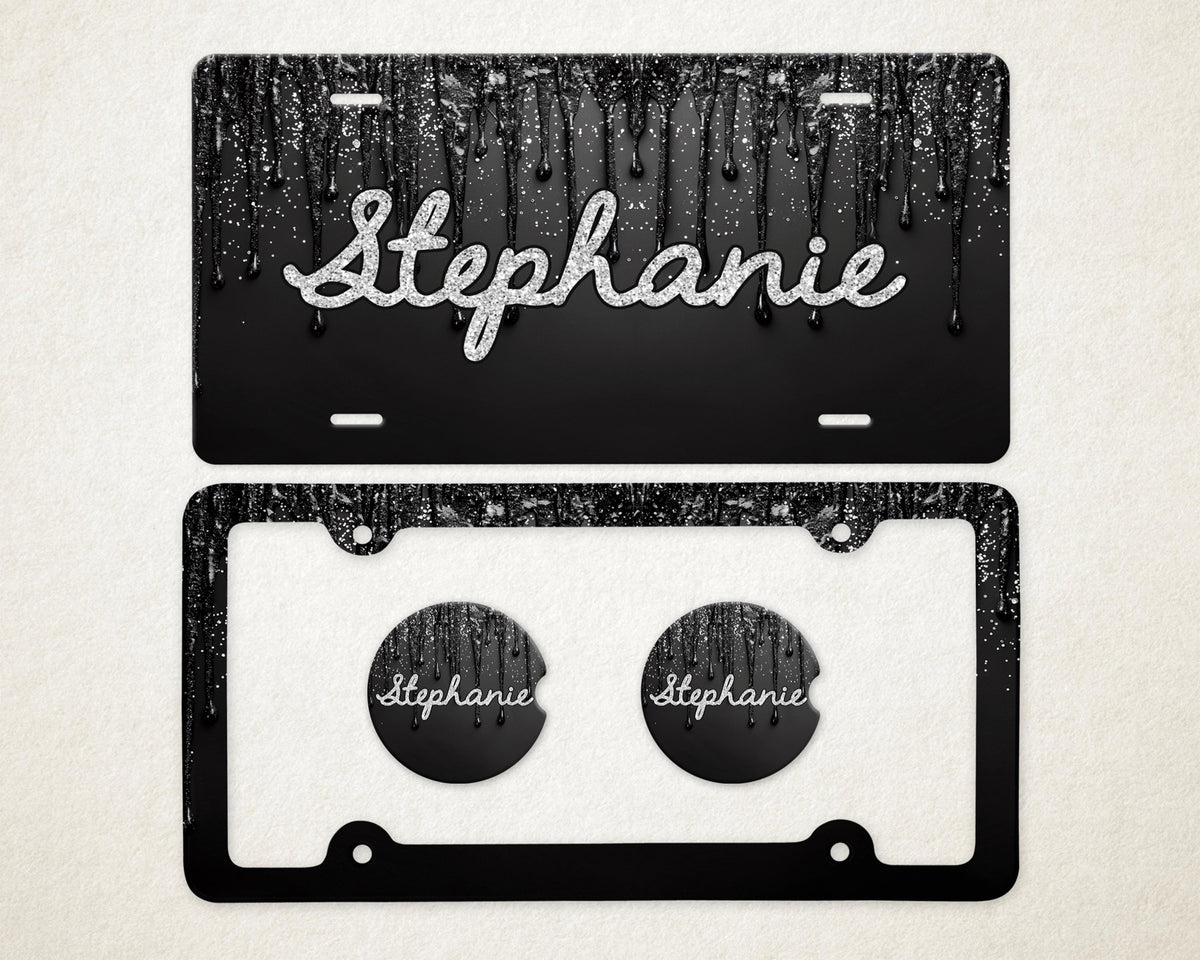 May include: Black license plate with a dripping paint design and the name "Stephanie" in silver glitter script. Includes a matching black license plate frame and two car coasters with the name "Stephanie".